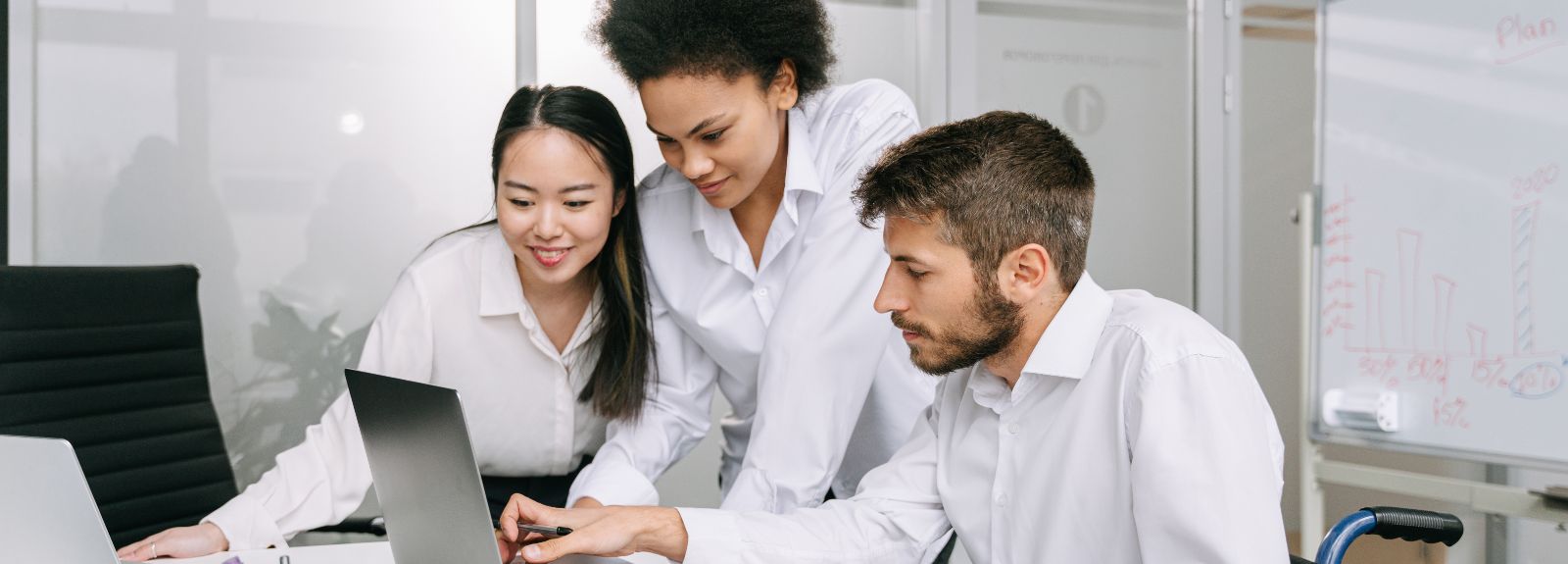 staff members sitting around a laptop chatting